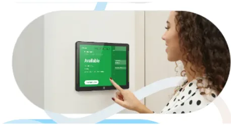 Person checking a room booking panel mounted beside a meeting room door